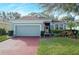 One-story house with a green exterior, red brick driveway and well-manicured lawn at 2311 Caledonian St, Clermont, FL 34711