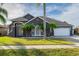 Gray house with palm trees, two-car garage, and well-manicured lawn at 2566 Ballard Ave, Orlando, FL 32833