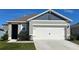 One-story home with gray siding, white garage door, and landscaping at 2965 Moulin Rd, Davenport, FL 33837