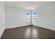 Bright bedroom with dark hardwood floors and two large windows at 3028 Kensington Ave, Davenport, FL 33837