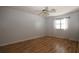 Bright bedroom features wood floors, a ceiling fan, and natural light from the window at 34122 Park Ln, Leesburg, FL 34788