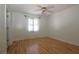 Bright bedroom features wood floors, a ceiling fan, and natural light from the window at 34122 Park Ln, Leesburg, FL 34788