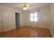 This bedroom features hardwood floors, ceiling fan, and a sunny window at 34122 Park Ln, Leesburg, FL 34788