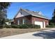 Home exterior featuring a brick facade, two-car garage, and established landscaping at 34122 Park Ln, Leesburg, FL 34788