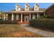 Inviting brick home featuring a covered porch, green shutters, and landscaped front yard at 34122 Park Ln, Leesburg, FL 34788