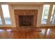 Red brick fireplace flanked by glass doors and hardwood flooring at 34122 Park Ln, Leesburg, FL 34788