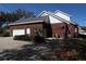 Brick two-car garage featuring an attached workshop area and a concrete driveway at 34122 Park Ln, Leesburg, FL 34788