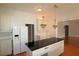 Spacious kitchen with a center island, white cabinets, and modern stainless steel appliances at 34122 Park Ln, Leesburg, FL 34788