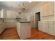 Bright kitchen featuring white cabinets, a center island, and stainless steel appliances at 34122 Park Ln, Leesburg, FL 34788