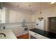 Well-lit kitchen with white cabinets, black countertop island, and stainless-steel appliances at 34122 Park Ln, Leesburg, FL 34788