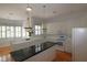 Bright kitchen with white cabinets, black countertop island, and stainless-steel appliances at 34122 Park Ln, Leesburg, FL 34788