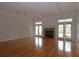 Spacious living room featuring hardwood floors, a brick fireplace, and bright double doors at 34122 Park Ln, Leesburg, FL 34788