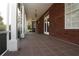 Covered porch with tiled flooring and white columns and a brick facade at 34122 Park Ln, Leesburg, FL 34788