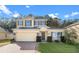 Two-story house with a yellow facade, gray roof, and a neatly landscaped lawn at 34405 Alameda Dr, Sorrento, FL 32776