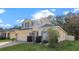 Two-story house with a yellow facade, gray roof, and a neatly landscaped lawn at 34405 Alameda Dr, Sorrento, FL 32776