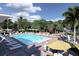 Community pool with lounge chairs, umbrellas, and surrounding landscaping at 402 N Pollard St, Oakland, FL 34787