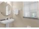 Small bathroom with pedestal sink and window at 4213 Whitemoor Ct, Clermont, FL 34711