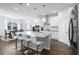 A modern white kitchen features an island with seating, stainless steel appliances, and hardwood floors at 4485 Lions Gate Ave, Clermont, FL 34711