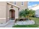 Inviting front entrance with palm tree and stone landscaping at 6030 Forest Ridge Ln, Winter Haven, FL 33881