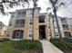 Exterior view of a condo building with palm trees and landscaping at 6100 Stevenson Dr # 105, Orlando, FL 32835