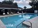 Community pool with lounge chairs and cabana at 7123 Yacht Basin Ave # 3, Orlando, FL 32835