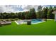 Luxury pool with artificial turf, lounge chairs, and spa at 717 Eastlawn Dr, Kissimmee, FL 34747