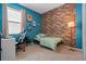 Bright bedroom with a brick accent wall, comfy bed, and workspace at 764 Sarner Pass Way, Winter Haven, FL 33881