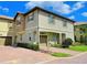 Two-story townhome featuring a covered car-port, neutral paint, brick driveway, and manicured shrubs at 1312 Shinnecock Hills Dr, Davenport, FL 33896