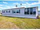 Gray manufactured home with sunroom and grassy yard at 1401 W Highway 50 # 138, Clermont, FL 34711