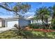 Light blue house with palm trees, well-manicured lawn, and attached garage at 14783 Yorkshire Run Dr, Orlando, FL 32828