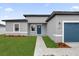 New construction home with gray exterior, blue garage door, and landscaped lawn at 15568 Sw 46Th Cir, Ocala, FL 34473