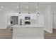 Kitchen island with stainless steel appliances, sleek white cabinetry, and pendant lights at 15568 Sw 46Th Cir, Ocala, FL 34473