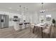 Modern kitchen with stainless steel appliances, white cabinets, pendant lighting, and an island with bar seating at 15568 Sw 46Th Cir, Ocala, FL 34473