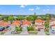 This aerial shows a neighborhood with well-maintained lawns, lovely landscaping, and uniform terracotta tile roofs at 2317 Santa Lucia St, Kissimmee, FL 34743