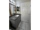 A gray vanity with granite countertop, a mirror, and a shower at 2317 Santa Lucia St, Kissimmee, FL 34743