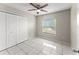 A bedroom with a ceiling fan, tile floors, and double closet doors to provide ample storage at 2317 Santa Lucia St, Kissimmee, FL 34743