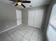 Bright bedroom with tile flooring, ceiling fan, and double-door closet at 2317 Santa Lucia St, Kissimmee, FL 34743