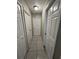 A long hallway with neutral walls and tile floors, featuring multiple doors to bedrooms and other rooms at 2317 Santa Lucia St, Kissimmee, FL 34743
