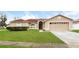 Tan house with red tile roof, two-car garage, and well-maintained lawn at 2543 Sage Dr, Kissimmee, FL 34758