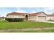 Tan one-story house with a two-car garage and a neatly landscaped yard at 2543 Sage Dr, Kissimmee, FL 34758