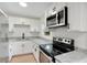 Modern kitchen with white cabinets, granite countertops, and stainless steel appliances at 2913 W Amelia St, Orlando, FL 32805