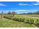 Landscaped backyard with golf course and tree-lined pathway at 3032 Kensington Ave, Davenport, FL 33837