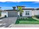 Modern house exterior with gray garage door and palm tree at 3032 Kensington Ave, Davenport, FL 33837