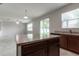 Modern kitchen featuring an island and dark brown cabinetry at 4617 Harvest Row Ln, St Cloud, FL 34772