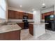 Kitchen with island, dark wood cabinets, and black appliances at 4617 Harvest Row Ln, St Cloud, FL 34772