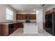 Kitchen with an island, dark wood cabinets, and black appliances at 4617 Harvest Row Ln, St Cloud, FL 34772