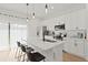 Contemporary kitchen with white cabinets, stainless steel appliances, and a quartz-topped island with bar seating at 709 Marion Oaks Mnr, Ocala, FL 34473
