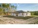 Single-story house showcasing a white exterior, a neutral-toned roof, and a wooden beam patio cover at 709 Marion Oaks Mnr, Ocala, FL 34473