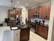 Modern kitchen with dark wood cabinets, granite island, and white backsplash at 7835 Syracuse Dr, Clermont, FL 34714