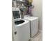 White washer and dryer in a well-lit laundry room with storage at 7835 Syracuse Dr, Clermont, FL 34714